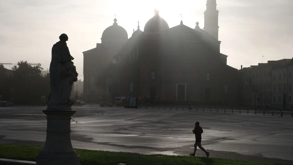 Empty Bormio piazza at dawn with the Italian Alps beyond