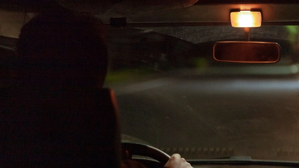 A self-drive visitor cresting the Stelvio summit in a classic Italian sports car.